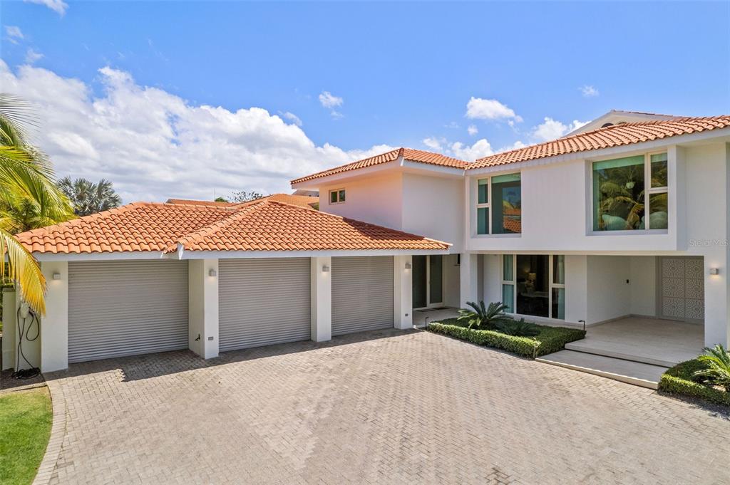 A two-story house with a three-car garage and a paved driveway under a blue sky — 336 DORADO BEACH EAST, DORADO, PR