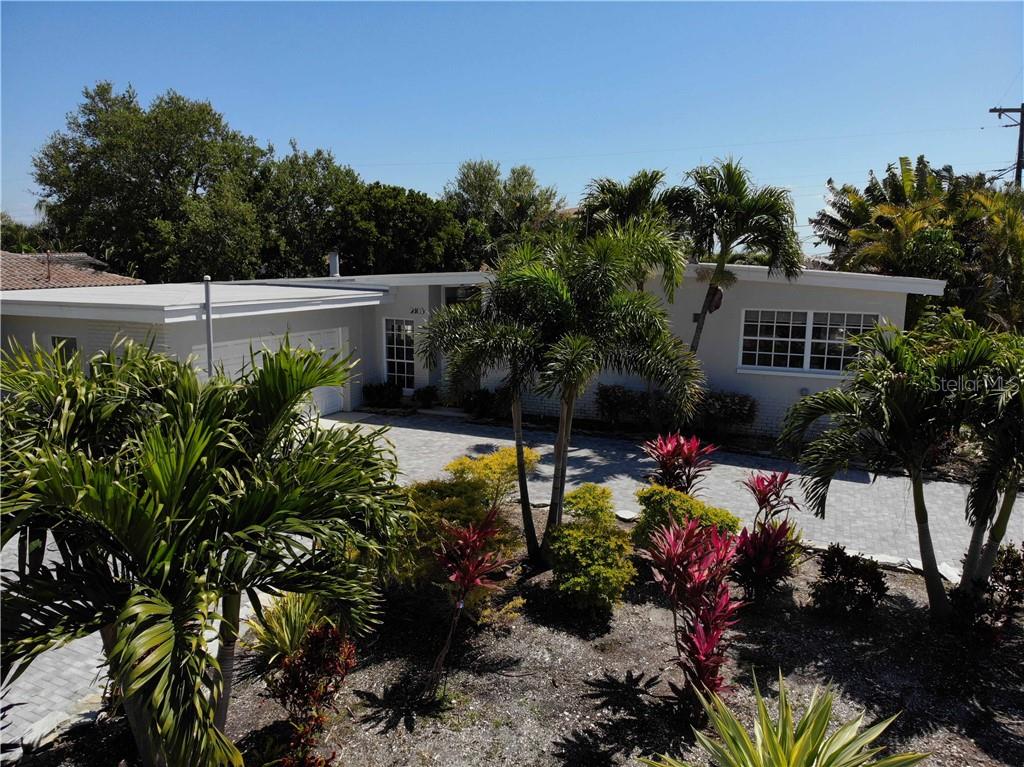 A single-story house with a flat roof, a paved driveway, and various palm trees — 2403 W VINA DEL MAR BOULEVARD, ST PETE BEACH, FL