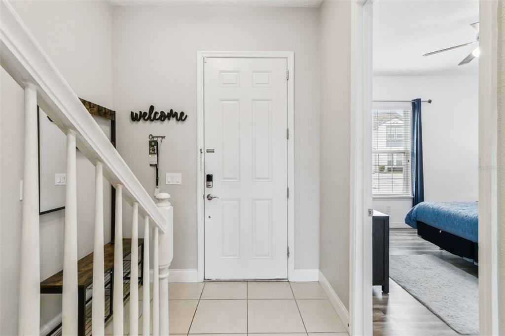 An entryway features a white front door, a staircase with a railing, and tiled flooring — 193 CAPTIVA DRIVE, DAVENPORT, FL
