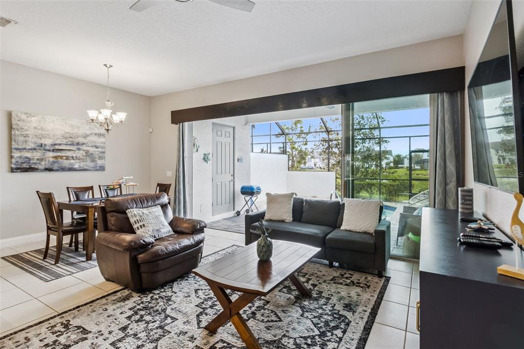A living and dining area features tile floors, a dark sofa, and a sliding glass door — 193 CAPTIVA DRIVE, DAVENPORT, FL