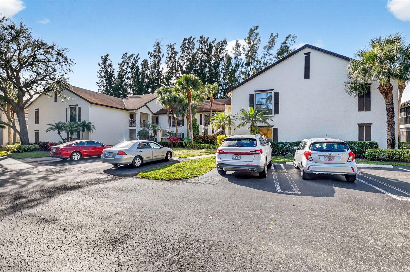 A two-story apartment building with a parking lot and several parked cars in front — 3227 Perimeter Drive, FL 33467, FL