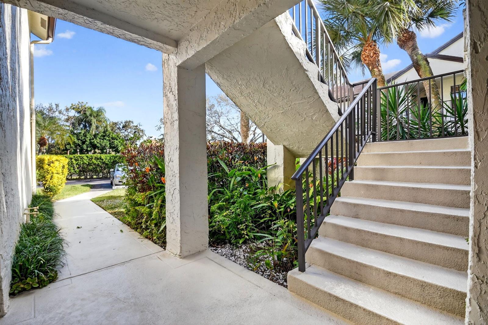 An outdoor concrete staircase with metal railings leads to an upper level near lush landscaping — 3227 Perimeter Drive, FL 33467, FL