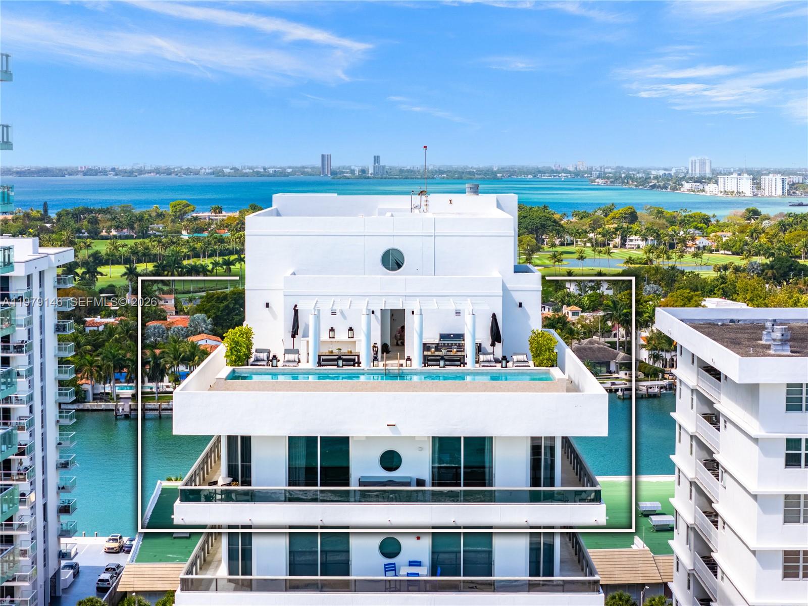 An aerial view of a high-rise building rooftop featuring a private swimming pool and patio — 5801 Collins Ave, Miami Beach FL 33140, MIAMI BEACH, FL