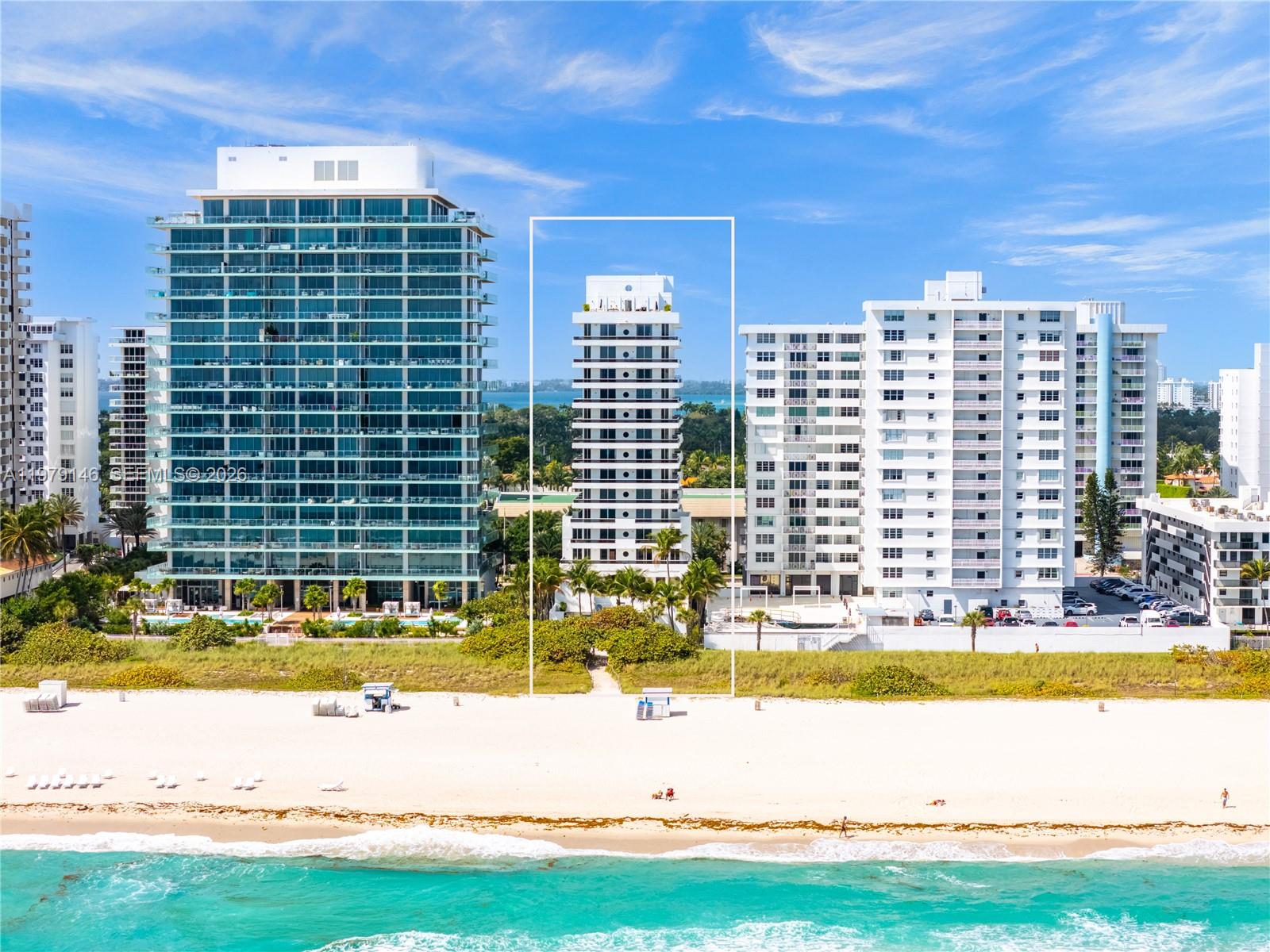An aerial view shows a white residential building centered between two larger high-rise towers — 5801 Collins Ave, Miami Beach FL 33140, MIAMI BEACH, FL