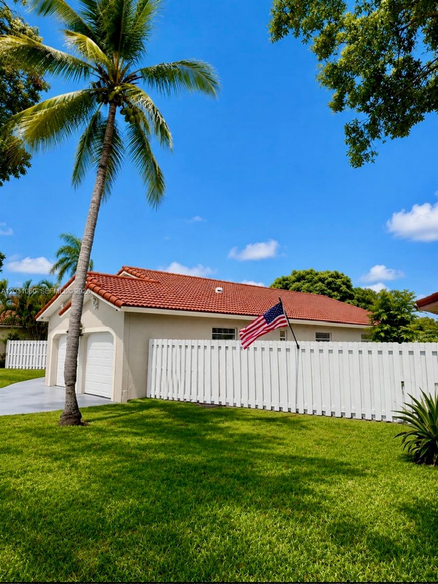 A single-story house with a red tile roof, white garage doors, and a white fence — 18145 NW 61st Ave, Hialeah FL 33015, HIALEAH, FL