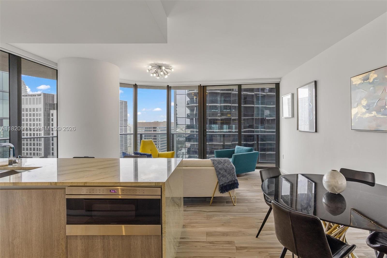 A modern living and dining area features floor-to-ceiling windows and a marble-topped kitchen island — 801 S Miami Ave # 4205, Miami FL 33130, MIAMI, FL