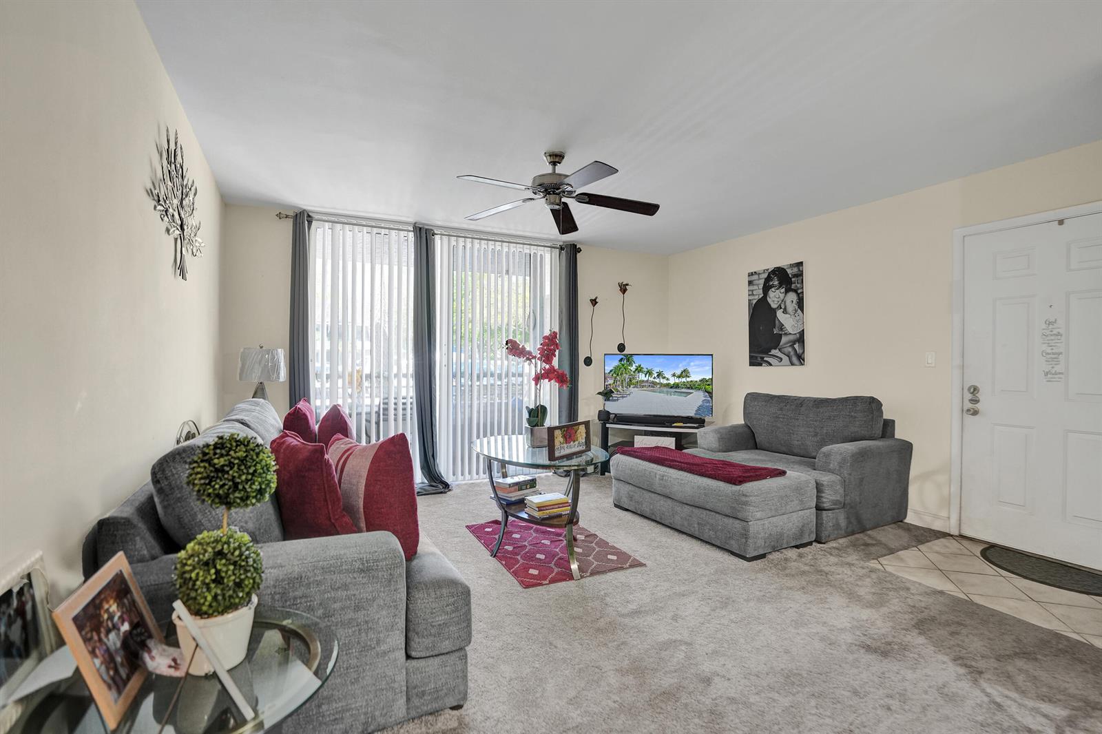 A living room features gray sofas, a glass coffee table, and a ceiling fan — 801 Lyons Road # 19103, Coconut Creek FL 33063, COCONUT CREEK, FL