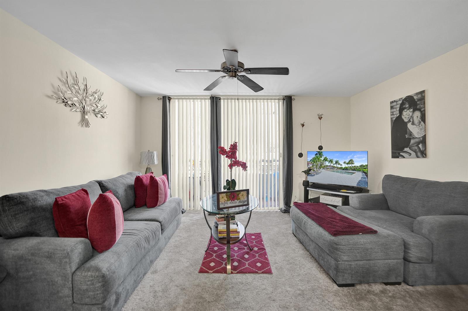 A living room features two gray sofas, a glass coffee table, and a television — 801 Lyons Road # 19103, Coconut Creek FL 33063, COCONUT CREEK, FL