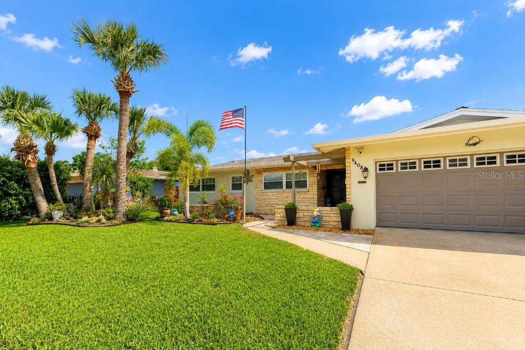 A single-story house with a stone facade, a two-car garage, and palm trees in the yard — 8408 BOULDER PLACE, TAMPA, FL