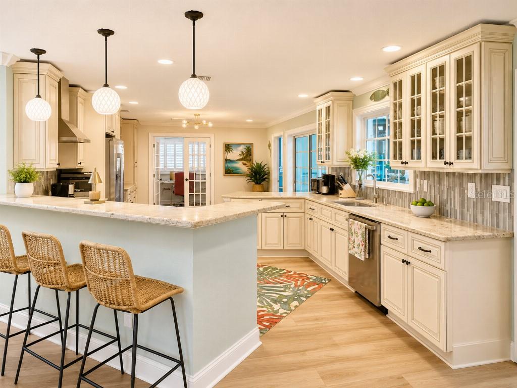 A kitchen with light-colored cabinets, granite countertops, a breakfast bar, and three woven bar stools — 8408 BOULDER PLACE, TAMPA, FL