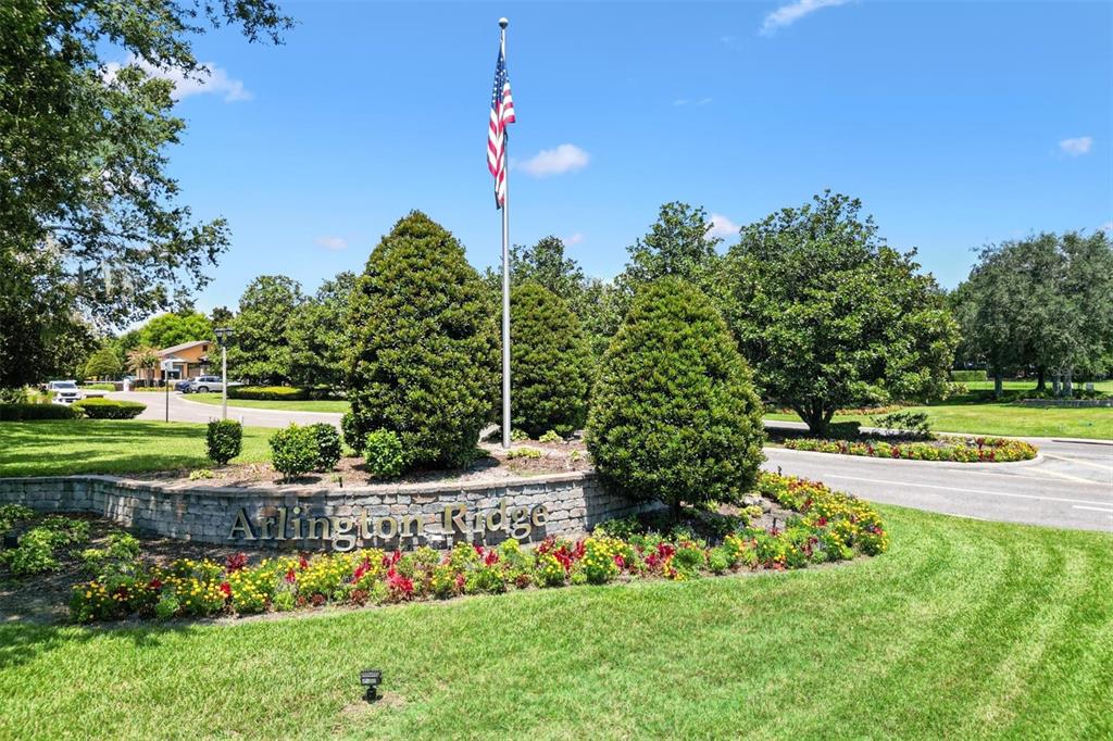 The entrance to Arlington Ridge features a stone sign, a flagpole, and landscaped gardens — 4110 ARLINGTON RIDGE BOULEVARD, LEESBURG, FL