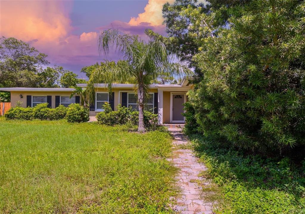 A single-story house with a stone walkway, a palm tree, and a grassy front yard — 210 BAKER AVENUE, CLEARWATER, FL