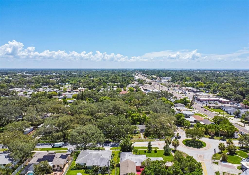 An aerial view shows a residential neighborhood with tree-lined streets and a nearby commercial road — 210 BAKER AVENUE, CLEARWATER, FL