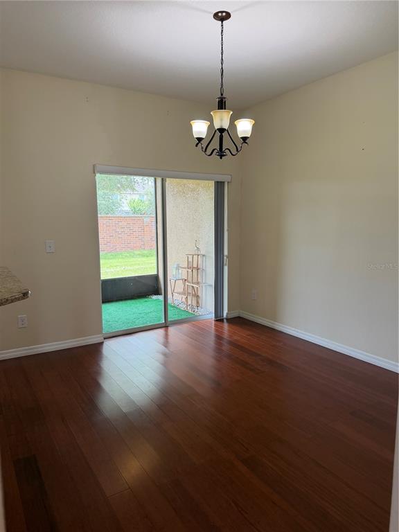 A dining area with hardwood floors, a chandelier, and a sliding glass door to a patio — 2914 RODRICK CIRCLE, ORLANDO, FL