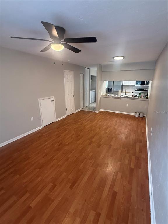 A kitchen features white shaker cabinets, black countertops, a stainless steel sink, and tile flooring — 4017 SW 22ND ROAD UNIT B, GAINESVILLE, FL