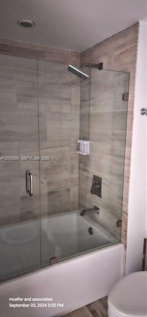 A modern bathroom features a glass-enclosed bathtub and shower with light-colored wood-look tile walls — 1300 Brickell Bay Dr # 2112, Miami FL 33131, MIAMI, FL