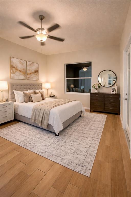 A bedroom features a tufted headboard, a wooden dresser, a ceiling fan, and wood-look flooring — 6002 RENAISSANCE COURT, ST CLOUD, FL