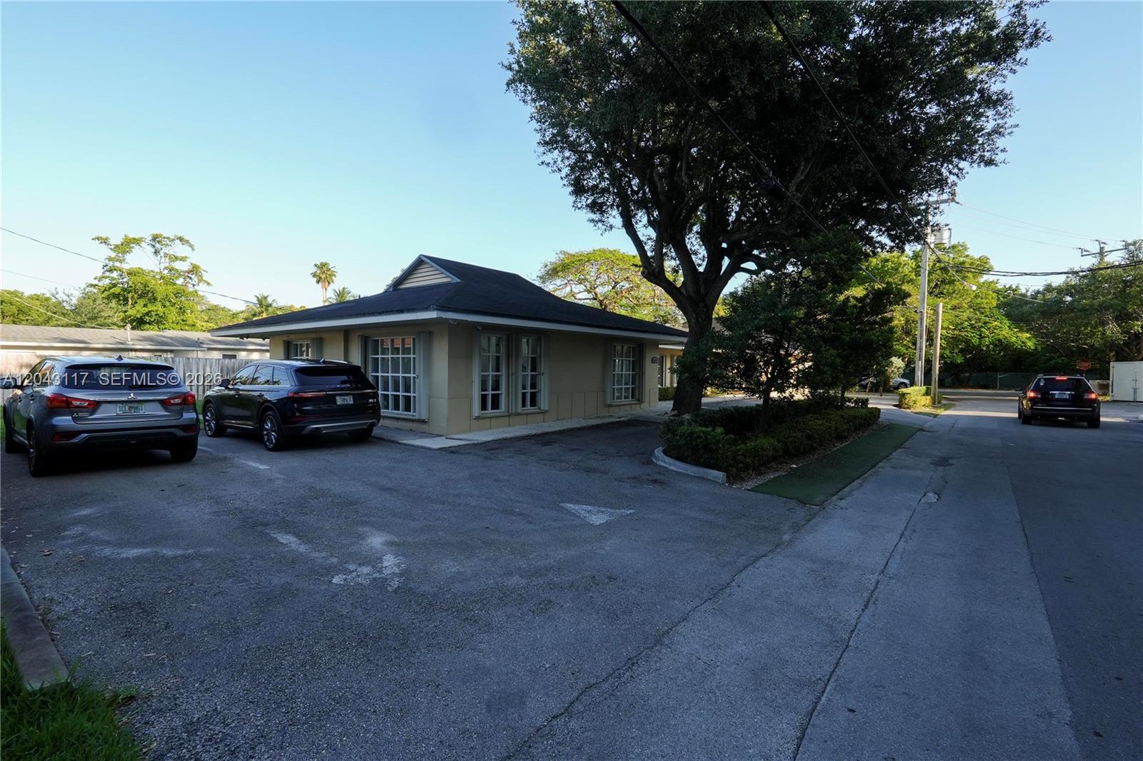 A single-story building with a parking lot and a large tree in the front — 8125 SW 120th St, Pinecrest FL 33156, PINECREST, FL