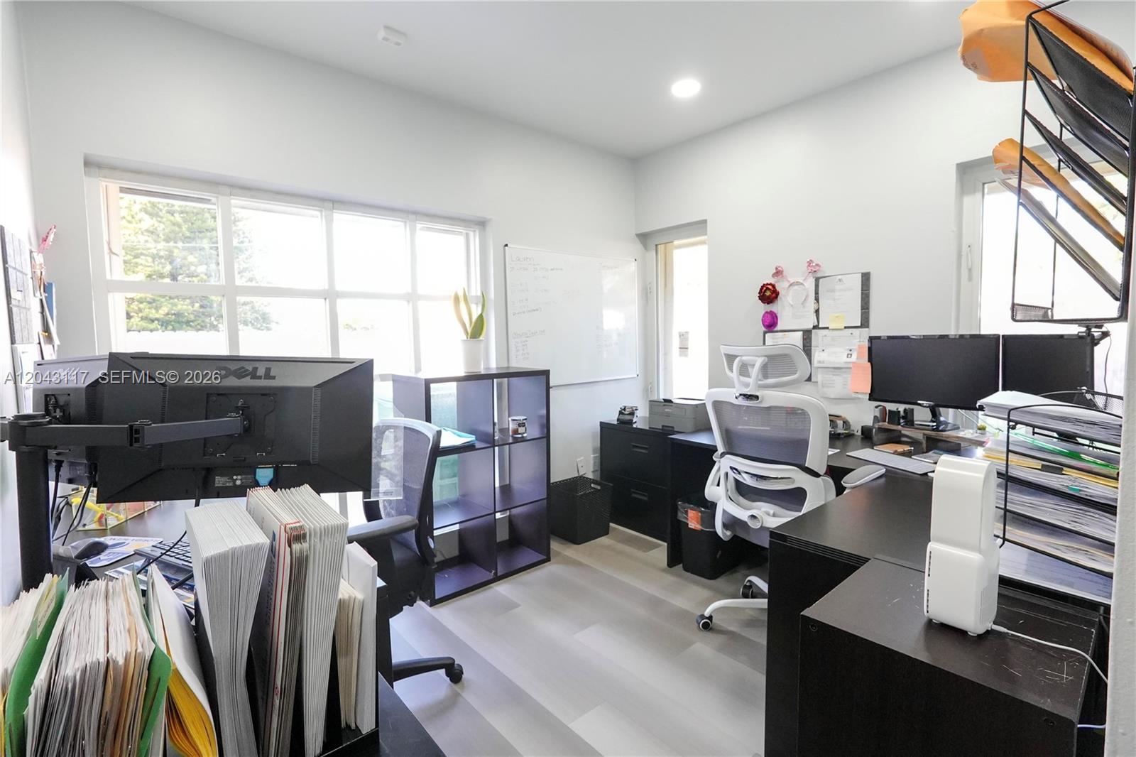 A home office features two desks, multiple computer monitors, a whiteboard, and light wood flooring — 8125 SW 120th St, Pinecrest FL 33156, PINECREST, FL