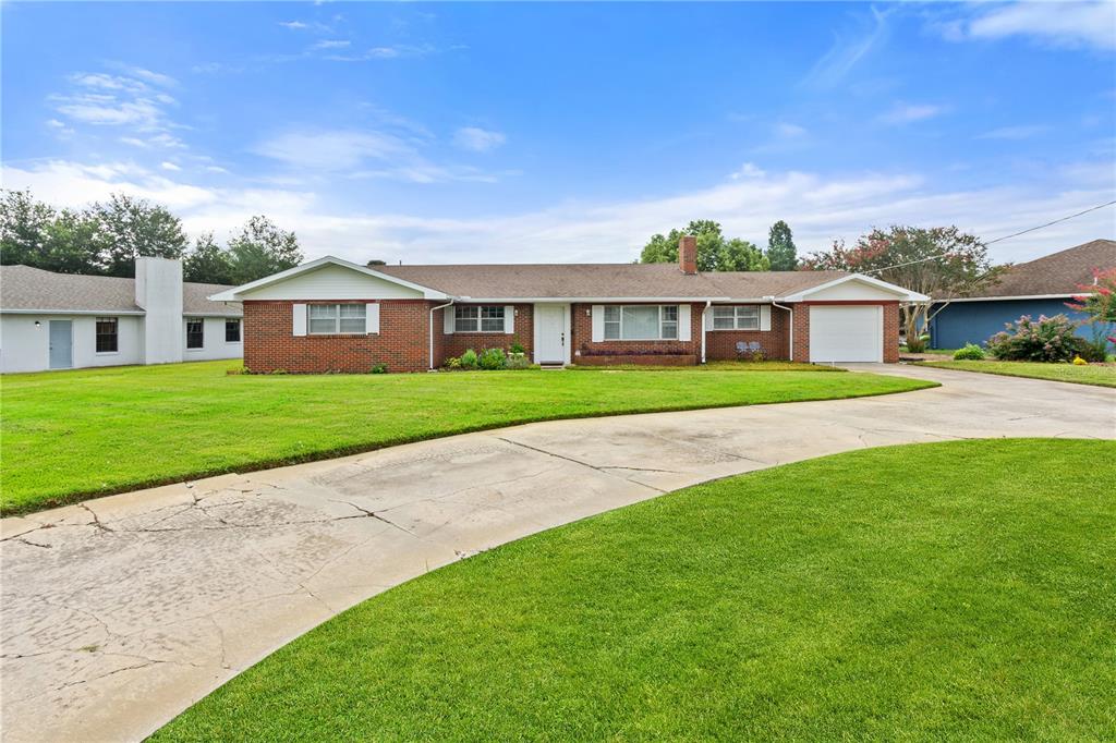 A single-story brick house with a white front door and an attached garage — 404 COLEMAN DRIVE, WINTER HAVEN, FL