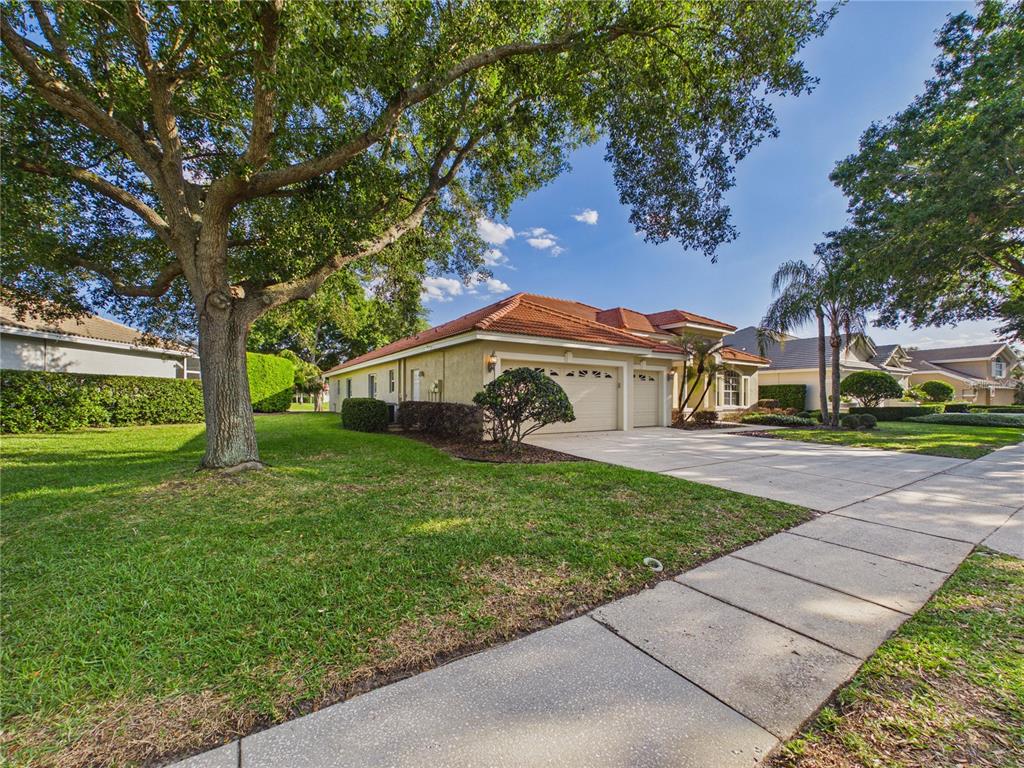 A single-story house with a tile roof, a three-car garage, and a concrete driveway — 10207 ESTUARY DRIVE, TAMPA, FL