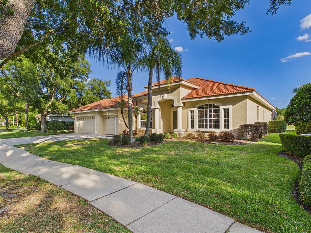 A single-story house with a tile roof, three-car garage, and a concrete driveway — 10207 ESTUARY DRIVE, TAMPA, FL