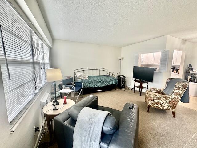 A living room features a bed, a television, and two armchairs on carpeted flooring — 583 Fanshaw, Boca Raton FL 33434, BOCA RATON, FL