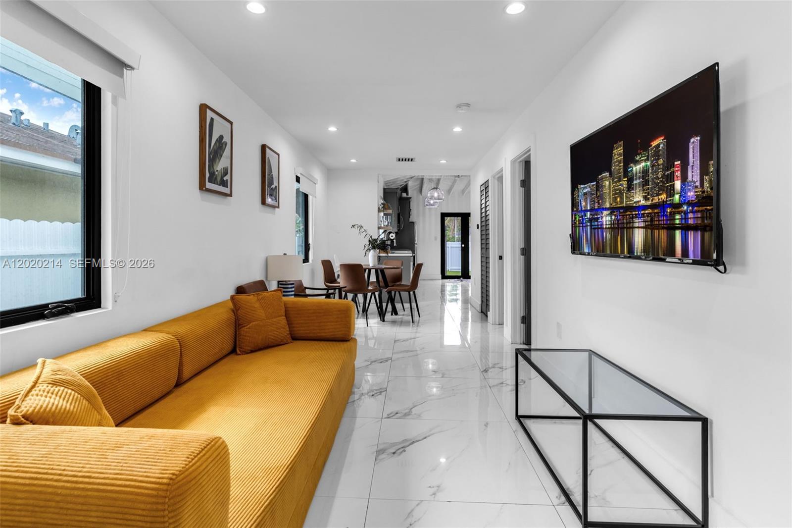 A living room features a yellow sofa, white marble floors, and a wall-mounted television — 2171 NW 49th St, Miami FL 33142, MIAMI, FL