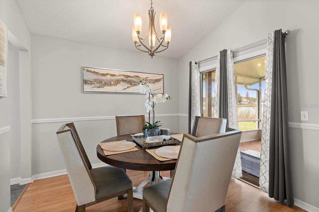 A dining room features a round wooden table, four upholstered chairs, and a chandelier — 3114 DELLCREST PLACE, LAKE MARY, FL
