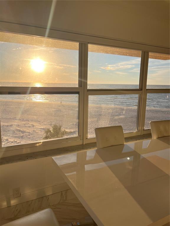 A dining area with a glossy white table overlooking a beach and the ocean — 880 MANDALAY AVENUE UNIT S302, CLEARWATER BEACH, FL