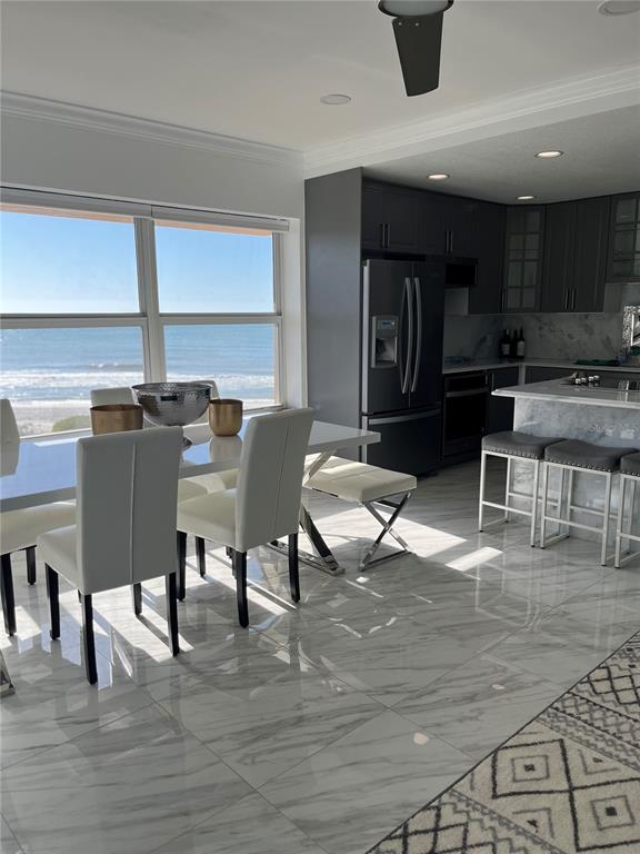 A dining area and kitchen with marble floors, white chairs, and an ocean view — 880 MANDALAY AVENUE UNIT S302, CLEARWATER BEACH, FL