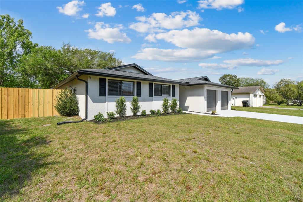 A single-story house with a white stucco exterior, dark roof, and a wooden fence — 2258 GEORGE WYTHE ROAD, ORANGE PARK, FL