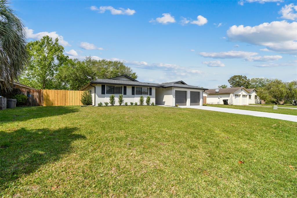 A single-story house with a white exterior, a two-car garage, and a large front lawn — 2258 GEORGE WYTHE ROAD, ORANGE PARK, FL