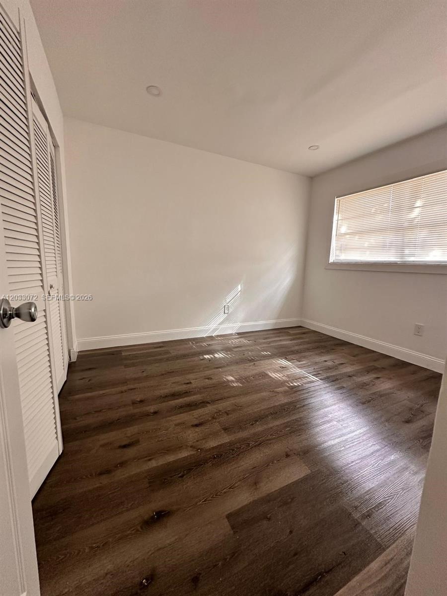 An empty bedroom features white walls, a window with blinds, and dark wood-look flooring — 5540 SW 38th Ct # 0, West Park FL 33023, WEST PARK, FL