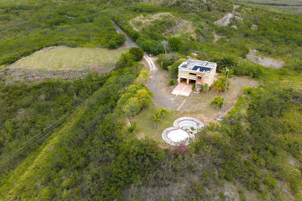 An aerial view shows a multi-story house with a pool on a hillside lot — 706 St SECTOT LA JULIA, SALINAS, PR