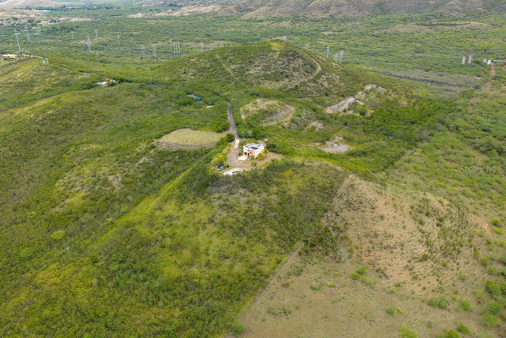 An aerial view shows a house with a pool situated on a grassy hillside — 706 St SECTOT LA JULIA, SALINAS, PR