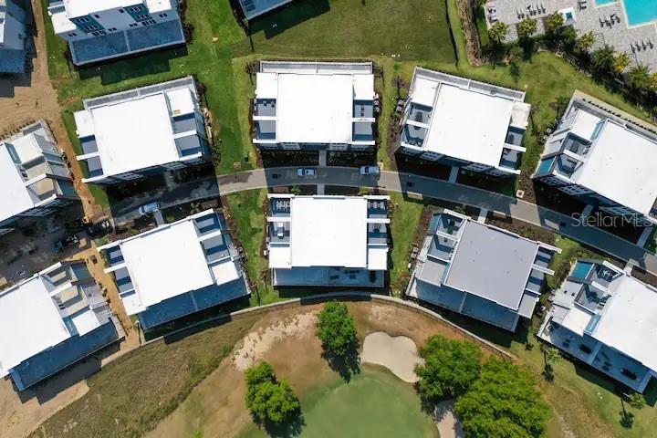 An aerial view shows several multi-story residential buildings arranged around a curved road — 7740 SANDY RIDGE DRIVE UNIT 223, KISSIMMEE, FL