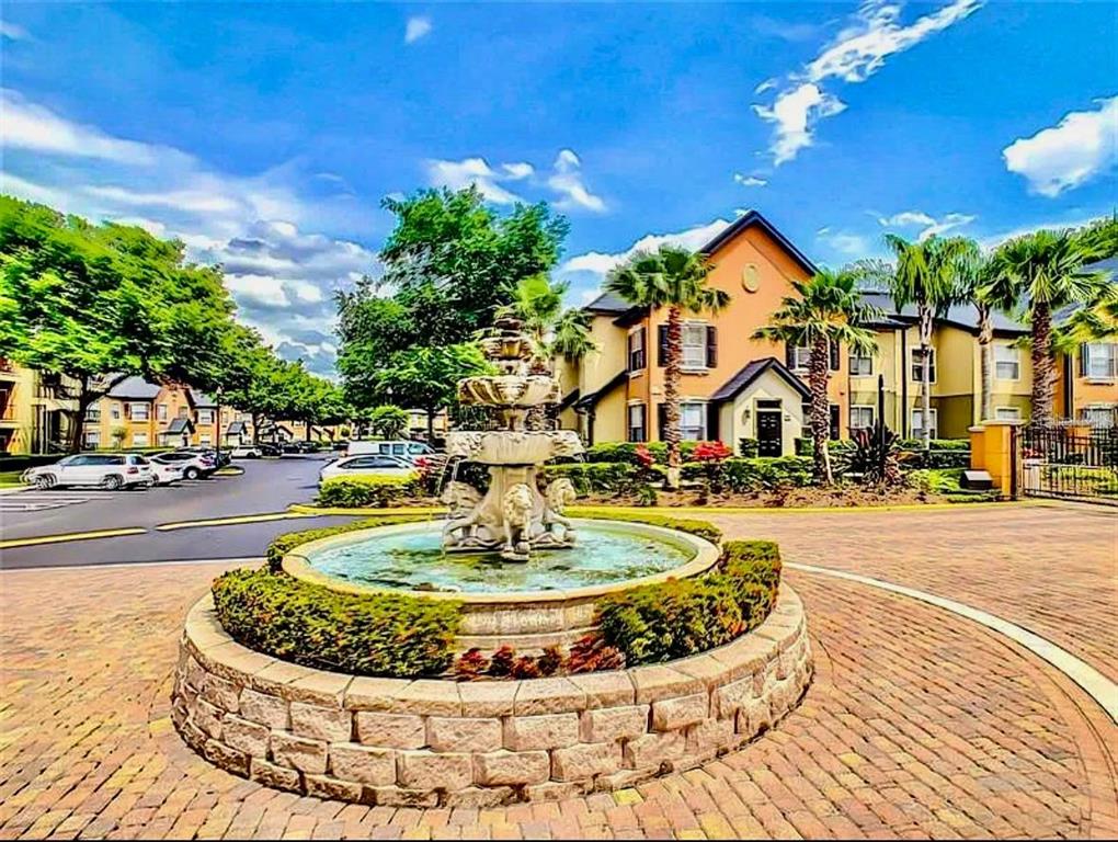 A stone fountain sits in the center of a brick driveway in front of apartment buildings — 6071 Westgate Dr WESTGATE DR UNIT 321, ORLANDO, FL