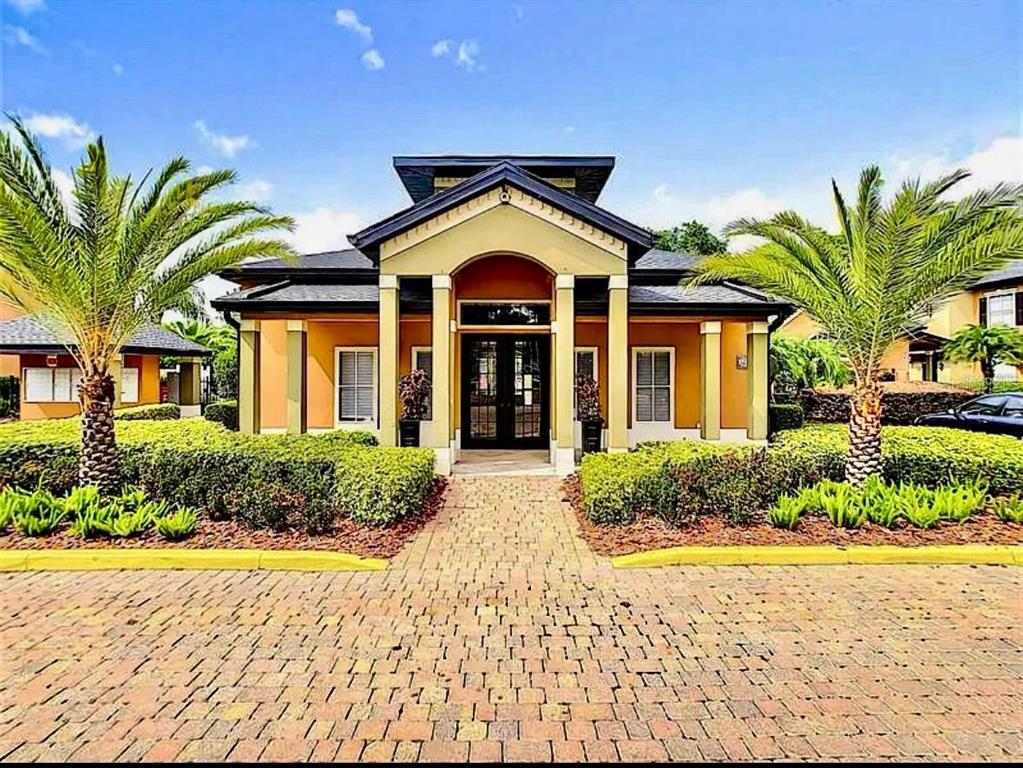 A single-story building with a brick walkway, palm trees, and a central arched entryway — 6071 Westgate Dr WESTGATE DR UNIT 321, ORLANDO, FL