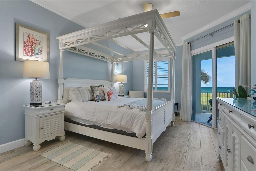 A bedroom with a white canopy bed, light blue walls, and a view of the ocean — 700 CINNAMON BEACH WAY UNIT 624, PALM COAST, FL