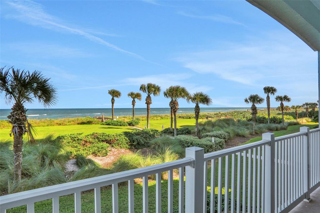 A balcony view overlooking a grassy lawn, palm trees, and the ocean — 700 CINNAMON BEACH WAY UNIT 624, PALM COAST, FL