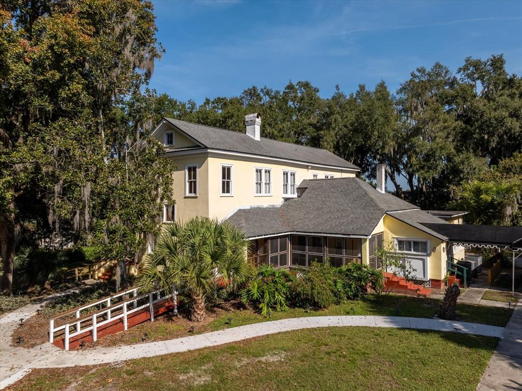 A two-story yellow house with a screened porch and a white ramp in the yard — 620 N TUBB STREET, OAKLAND, FL