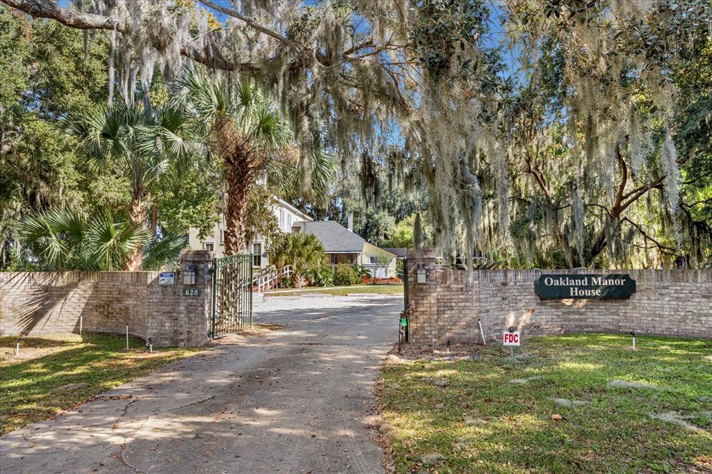 A brick wall with a gate and a sign marks the entrance to a property — 620 N TUBB STREET, OAKLAND, FL