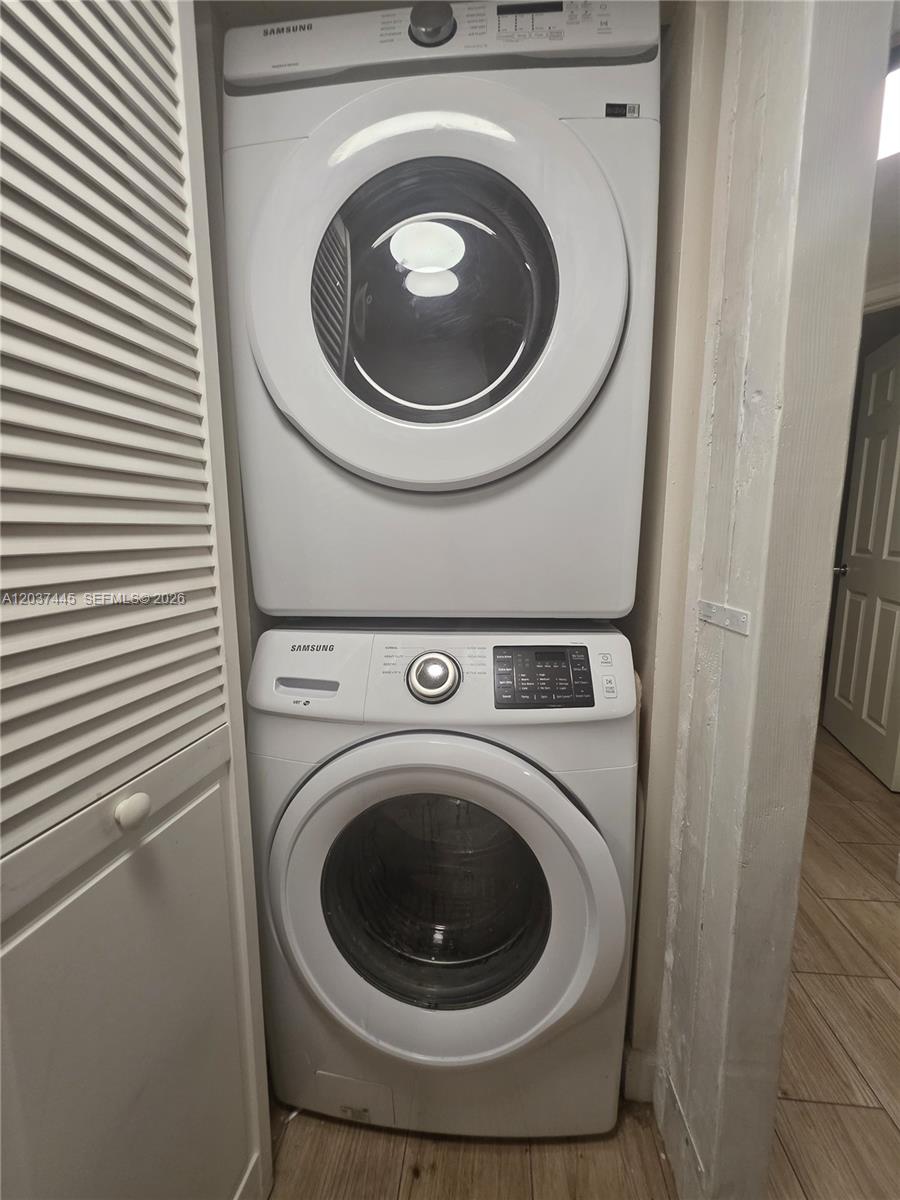 A stacked Samsung washer and dryer unit is installed in a small laundry closet — 15711 SW 137th Ave # 101, Miami FL 33177, MIAMI, FL