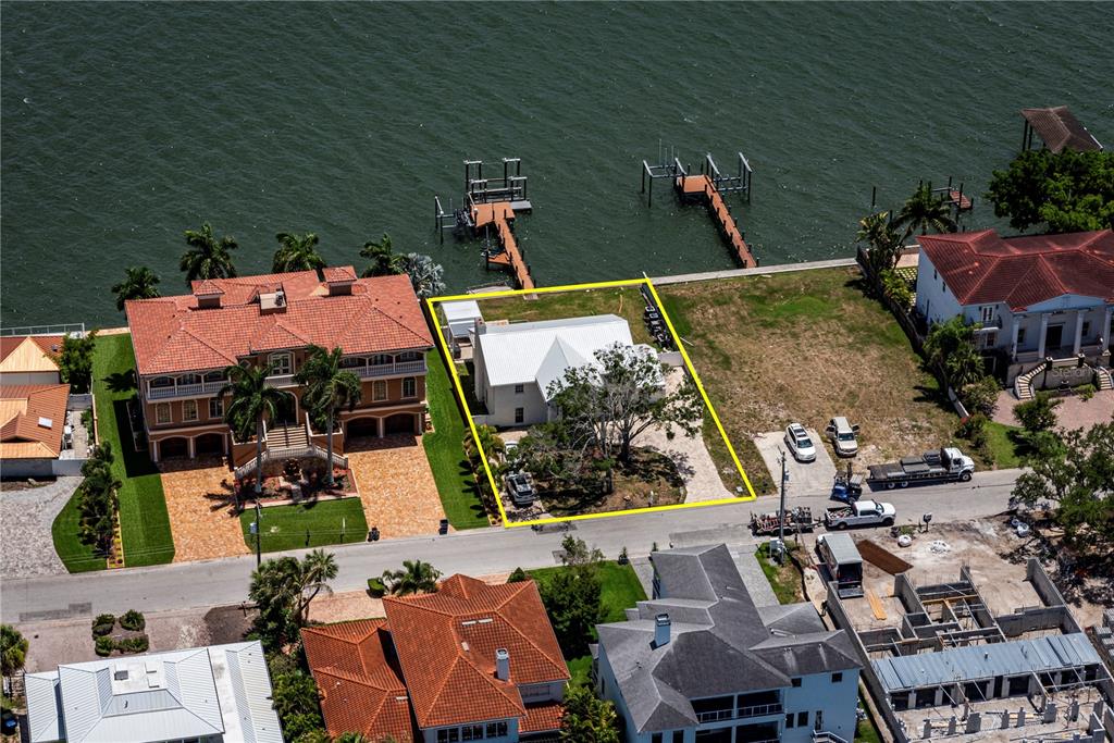 An aerial view shows a waterfront property with a white house and a private dock — 5812 MARINER STREET, TAMPA, FL