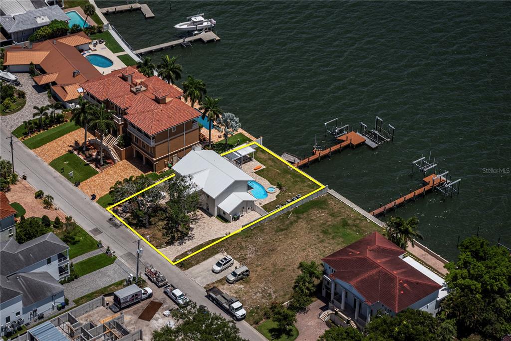 An aerial view shows a waterfront house with a pool and dock outlined in yellow — 5812 MARINER STREET, TAMPA, FL