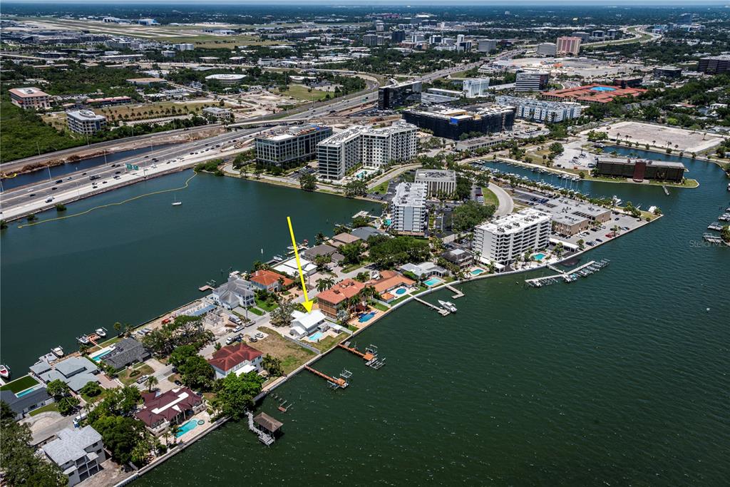 An aerial view shows a waterfront house with a pool and dock on a peninsula — 5812 MARINER STREET, TAMPA, FL