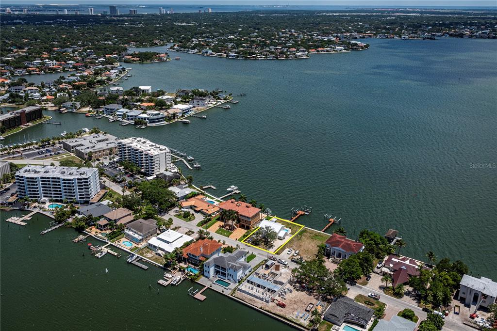 An aerial view shows a waterfront property highlighted in yellow along a residential coastline — 5812 MARINER STREET, TAMPA, FL