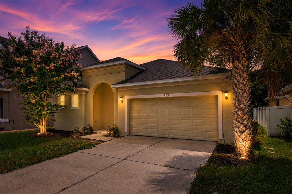 A brick wall with the word Remington sits behind a manicured hedge and flower bed — 908 MARISA LANE, KISSIMMEE, FL