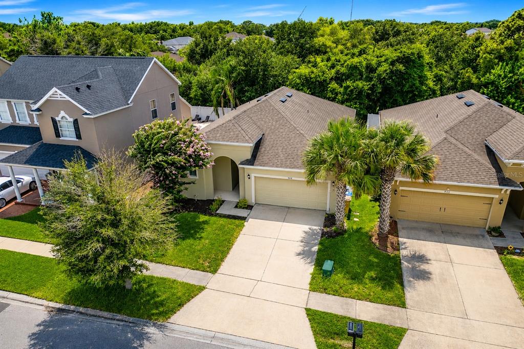 A single-story house with a yellow exterior, a two-car garage, and a palm tree — 908 MARISA LANE, KISSIMMEE, FL